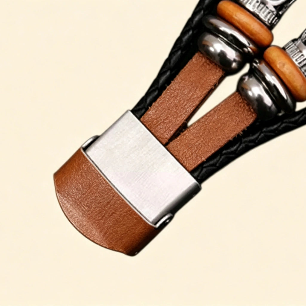 Amber brown leather Apple Watch strap lug connector — close-up showing filigree silver metallic tube sliders, wooden disc beads, hematite beads, and cognac leather quick-release lug with black braided cord, cream background