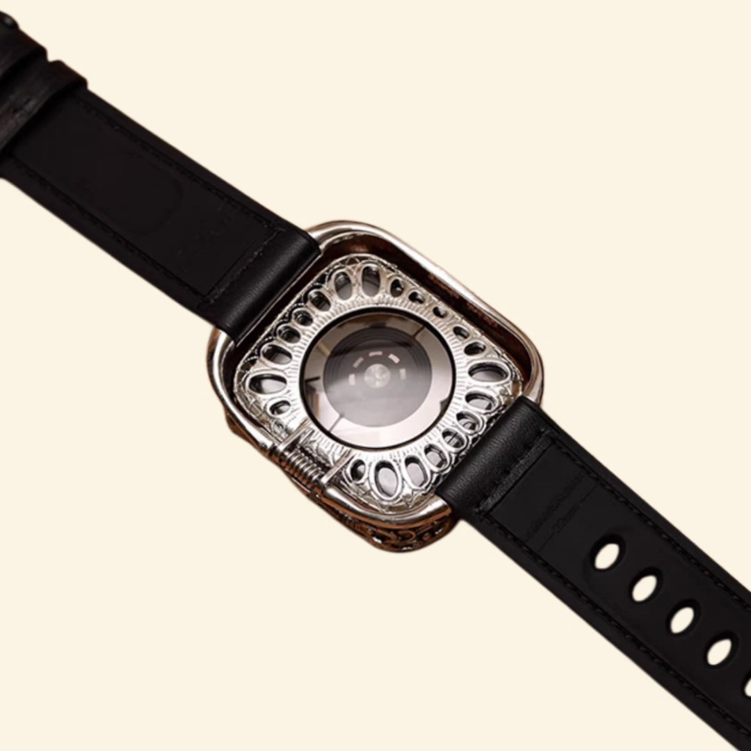 Baroque engraved antique silver Apple Watch case back view — spring-assisted dual hinge mechanism and heart rate sensor dome, black leather strap