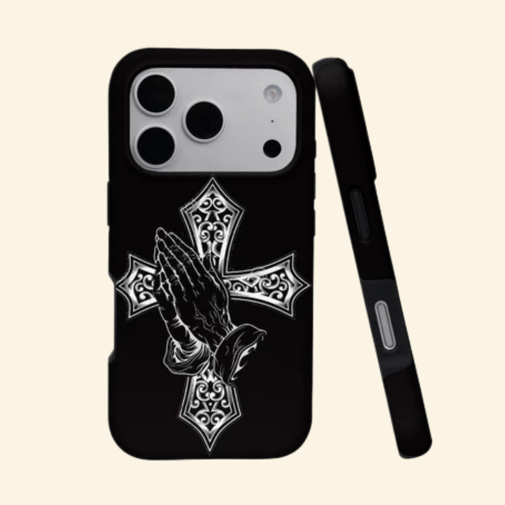 The Devotional Emblem case – angled top floating view showing praying hands over ornate silver gothic cross on matte black