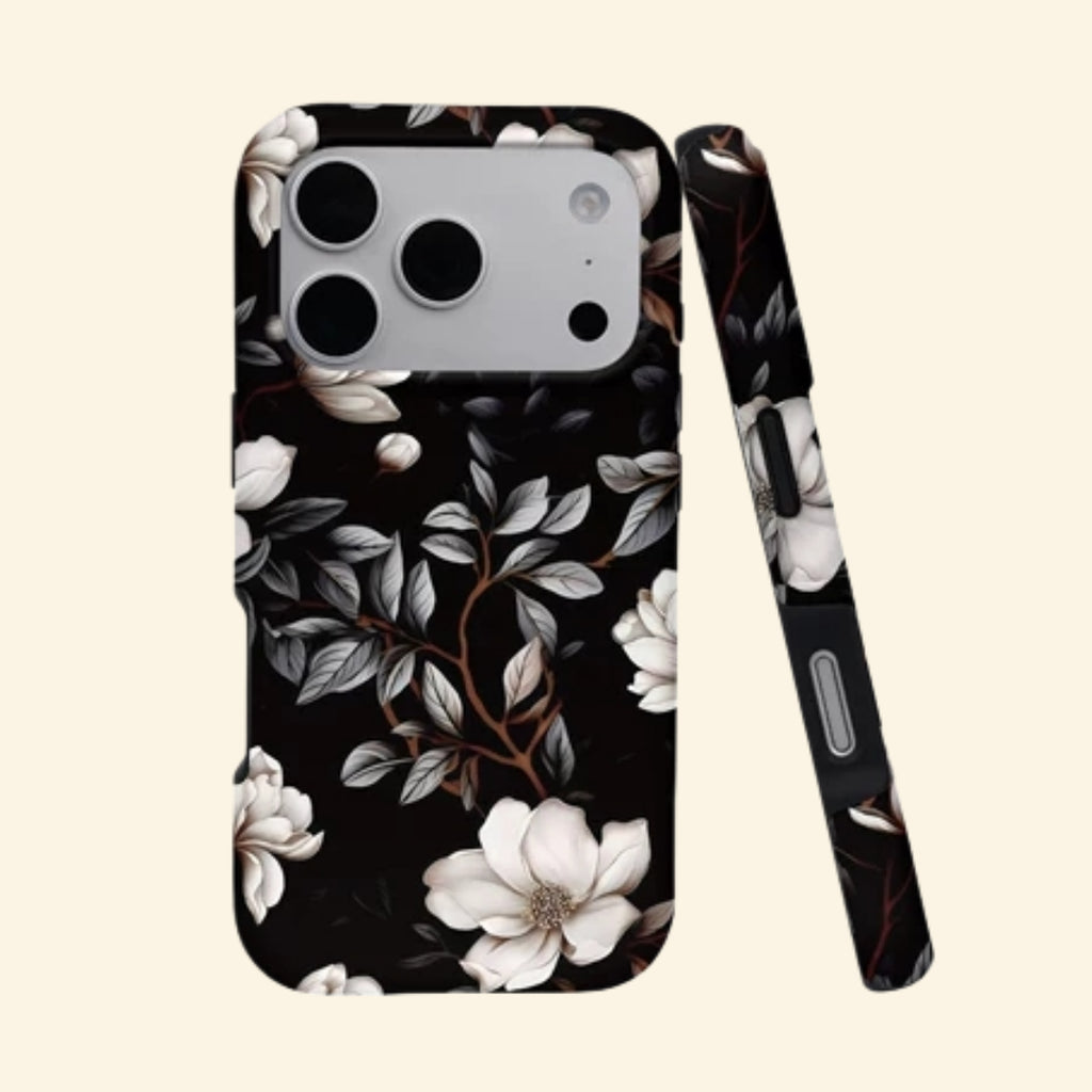 The Midnight Bloom case – front and side profile flat lay showing ivory magnolia blossoms and silver foliage on matte black