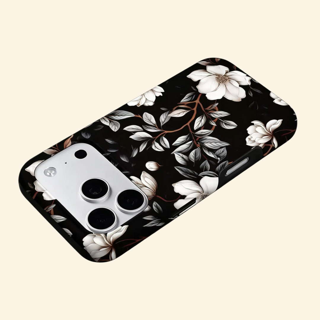 The Midnight Bloom case – low-angle top-down view showing camera island and ivory magnolia blossom detail