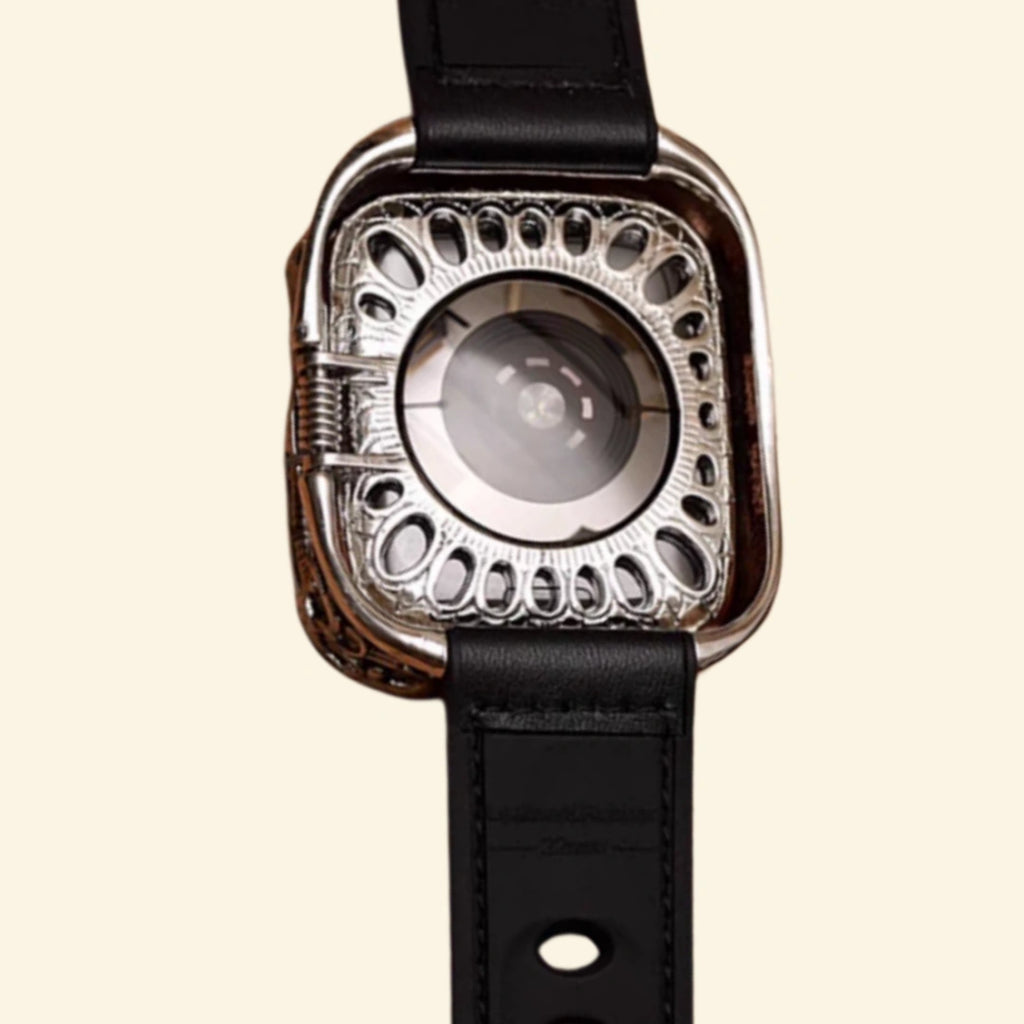 Baroque Archival Suite flat lay — silver engraved case with matte black leather hybrid strap and matte black pin buckle, diagonal angle