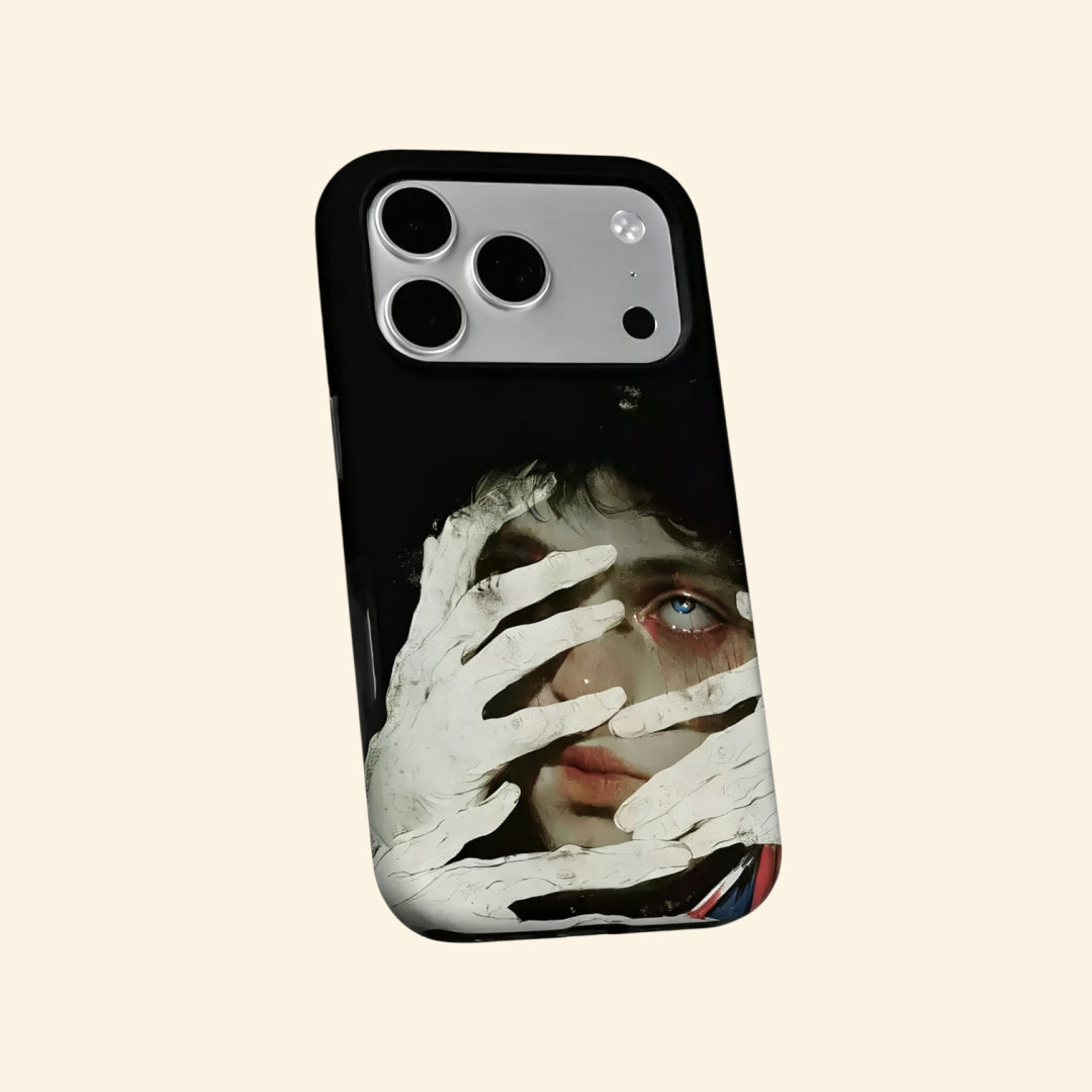 The Silent Gaze case – hand-held lifestyle shot showing full pale hands and blue eye surrealist portrait against obsidian backdrop