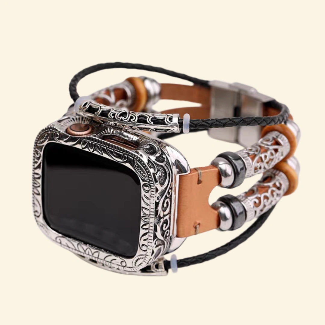 Baroque Archival Suite No. 10830 on wrist — close-up showing brushed stainless steel fold-over clasp closed, Apple Watch back sensor visible, amber brown leather and black braided cord multi-strand strap