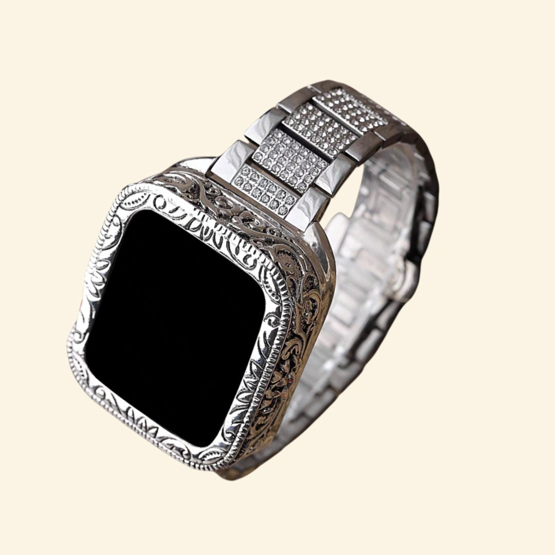 Baroque silver engraved Apple Watch case with pavé crystal stainless steel bracelet — three-quarter back-angle view showing full scrollwork bezel and crystal-set links, cream background