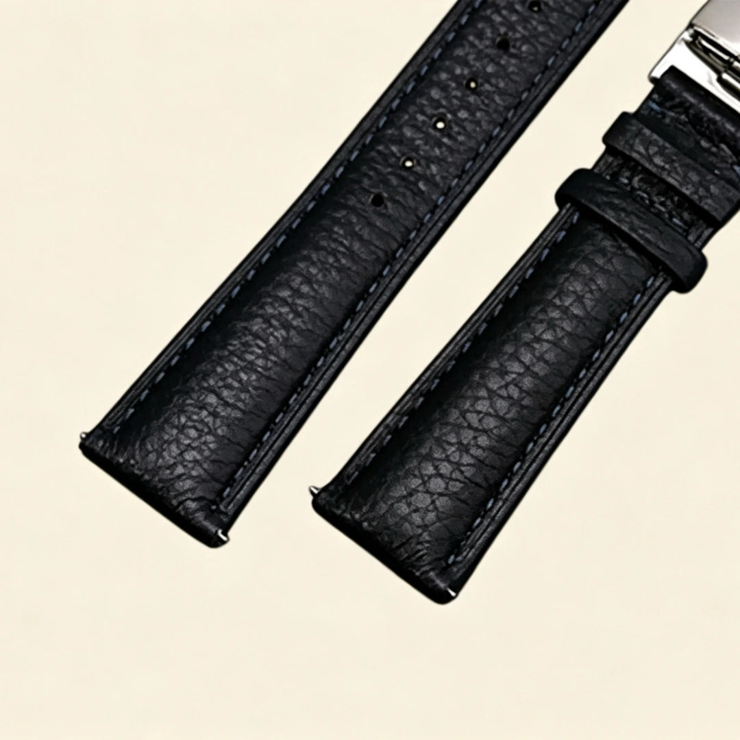 Baroque Archival Suite No. 10825 — silver engraved case with black genuine leather strap and silver cross emblem stud, three-quarter product shot on cream background