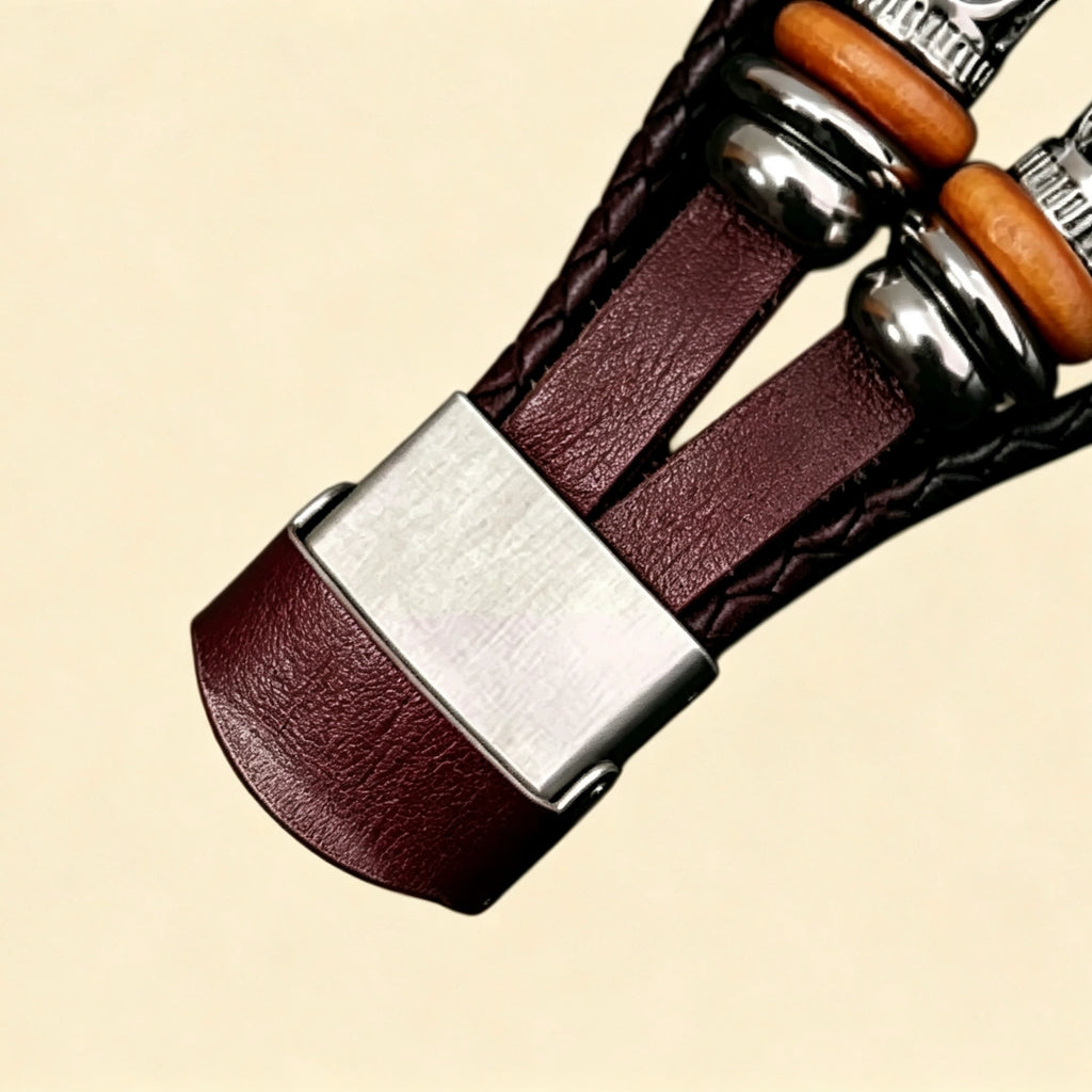 Burgundy braided leather Apple Watch strap — close-up of brushed stainless steel fold-over clasp open showing Apple Watch back sensor, multi-strand burgundy braid and wooden bead detail