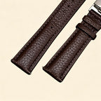 Dark espresso brown leather Apple Watch strap — close-up showing stainless steel butterfly deployment clasp fully open, wing mechanism and strap keeper detail