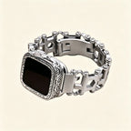 Stainless steel multitool bracelet close-up — double-locking foldover deployment clasp open, showing butterfly mechanism and engraved link detail
