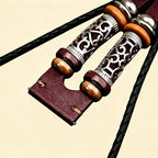 Burgundy braided leather Apple Watch strap lug end — close-up showing filigree metallic tube sliders, wooden disc beads, hematite beads, and burgundy leather quick-release lug connector