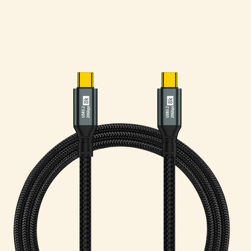100W 20Gbps 8K USB-C braided data cable — both gold-plated USB-C connectors shown with gunmetal alloy housings labeled USB3.2 20Gbps 8K, coiled black high-density braided nylon cable on cream background